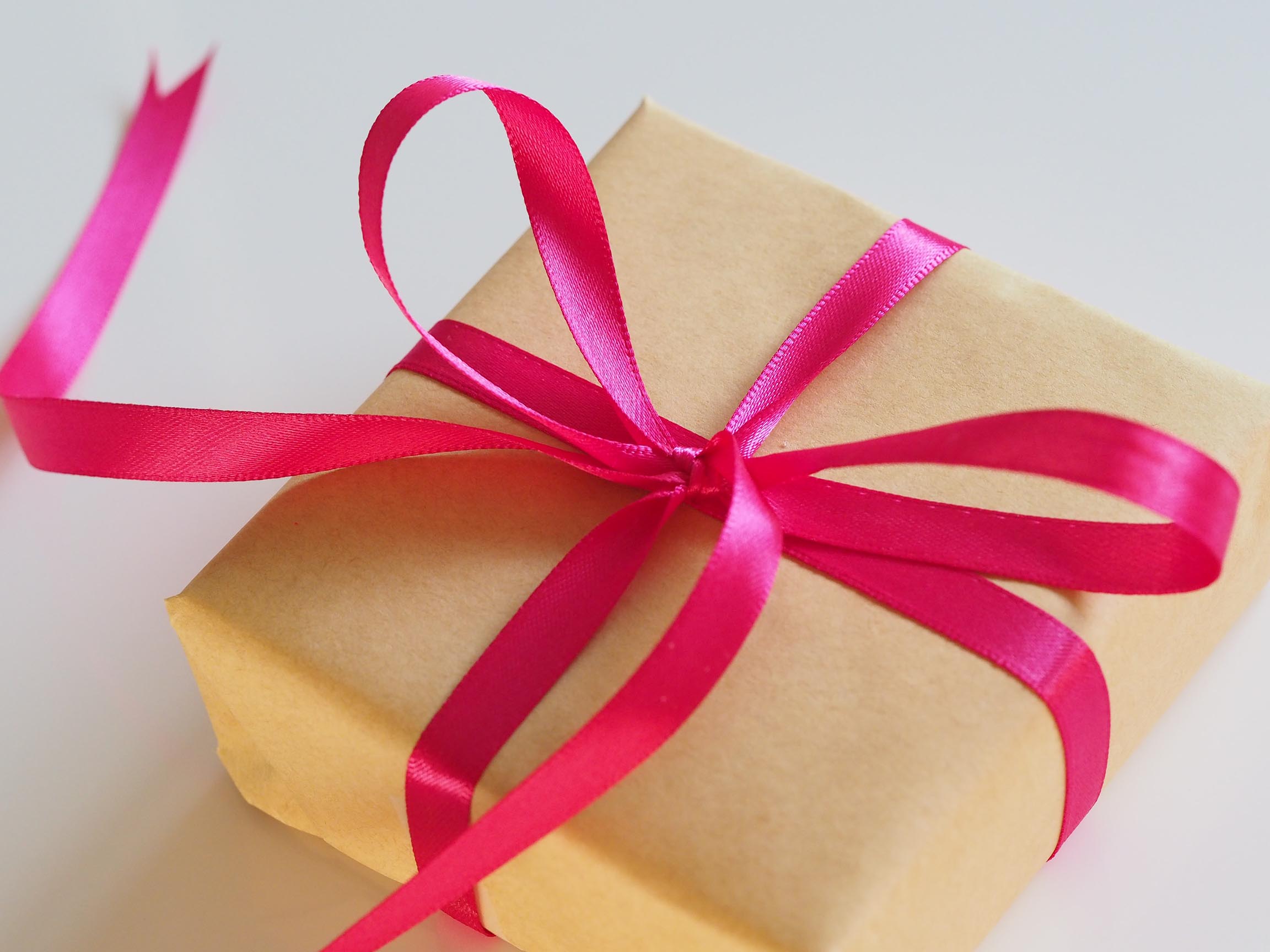 Image of a gift wrapped in paper tied with a ribbon